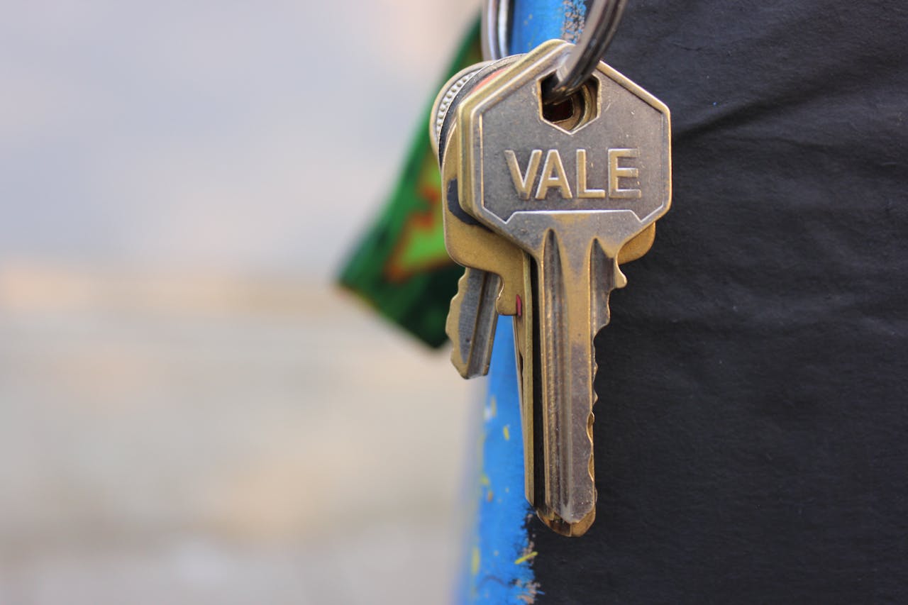 team-02 A detailed view of a metallic key with 'Vale' engraved on it, hanging against a blurred background.