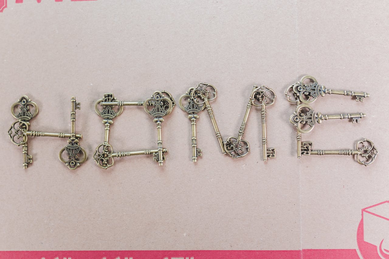 services-02 Artistic arrangement of vintage keys spelling 'HOME' on a cardboard surface, creating a rustic still life.
